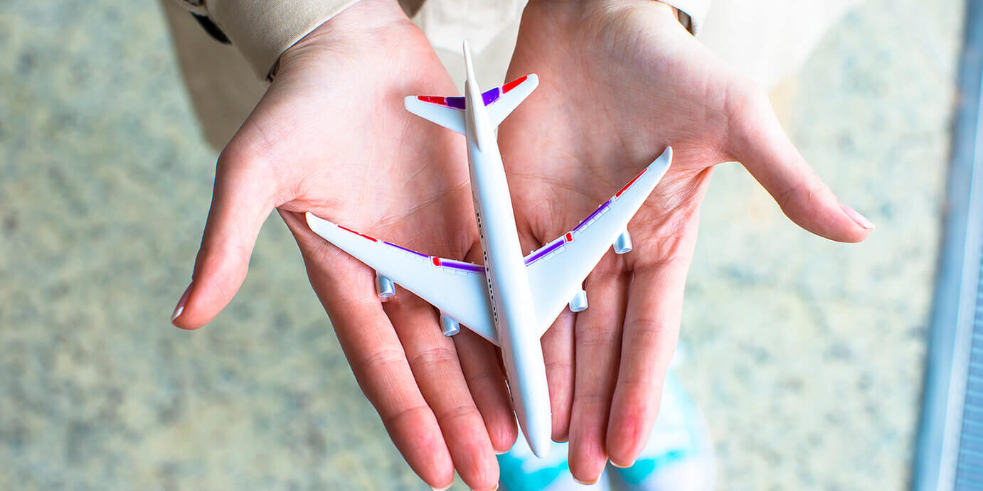 closeup-hand-holding-an-airplane-model-at-airport-2023-11-27-04-49-40-utc